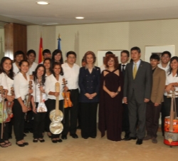 Fotografía de grupo de Su Majestad la Reina junto a los jóvenes músicos de la Orquesta de Instrumentos Reciclados de Cateura, la soprano Pilar Jurado 